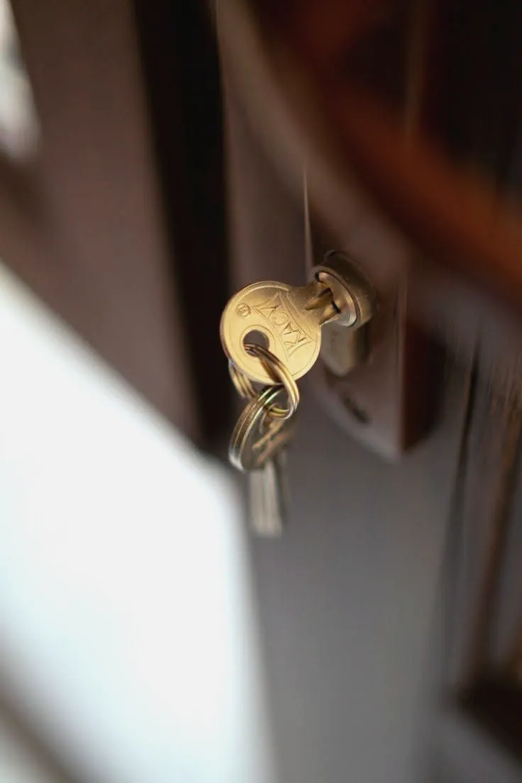 Llave introducida en la cerradura de una puerta de madera