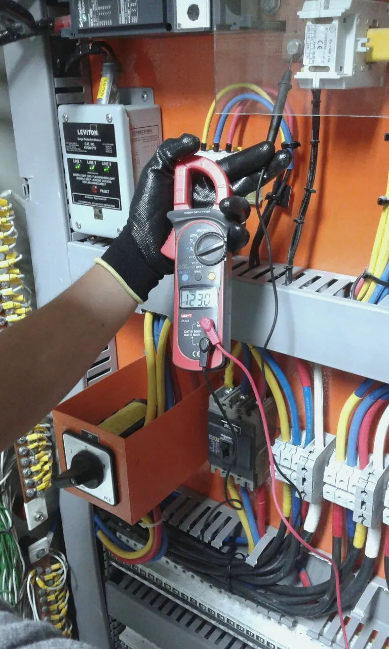Electricista midiendo con pinza amperimétrica en un cuadro eléctrico